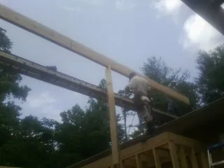 Carpenter setting a ridge beam over a new addition frame — Ice Dam Removal by Roofing Brothers in Rockwell City