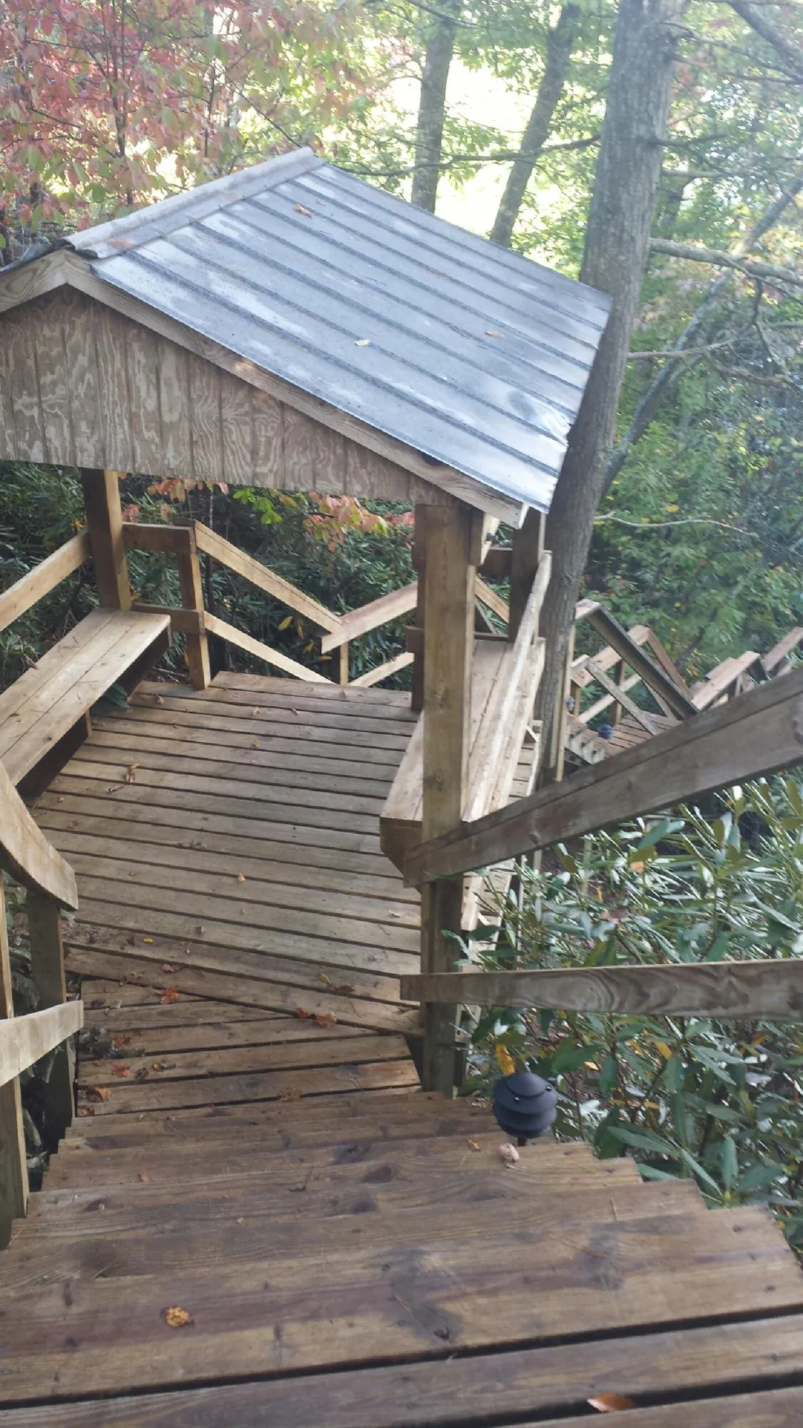 Metal roofed shelter over wooden steps on a wooded walkway — Skylight Repair & Installation work by our crew in Rockwell City
